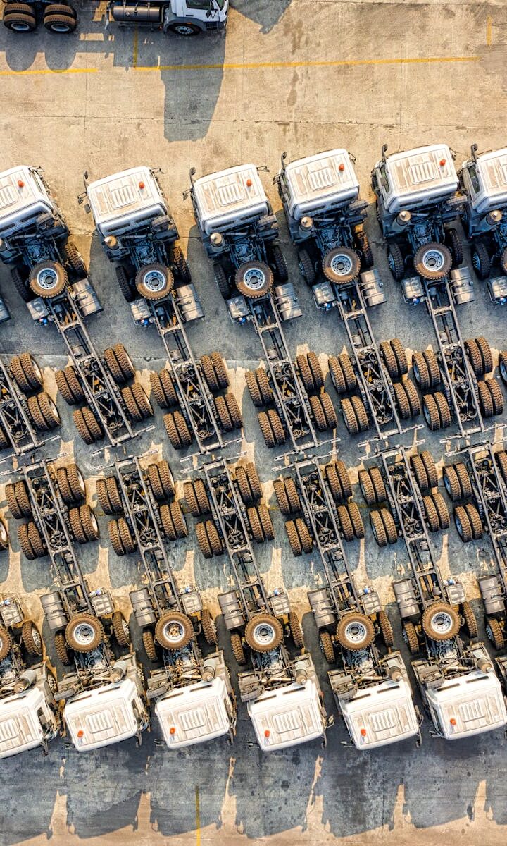 Aerial shot of multiple trucks parked in rows, highlighting transportation logistics.