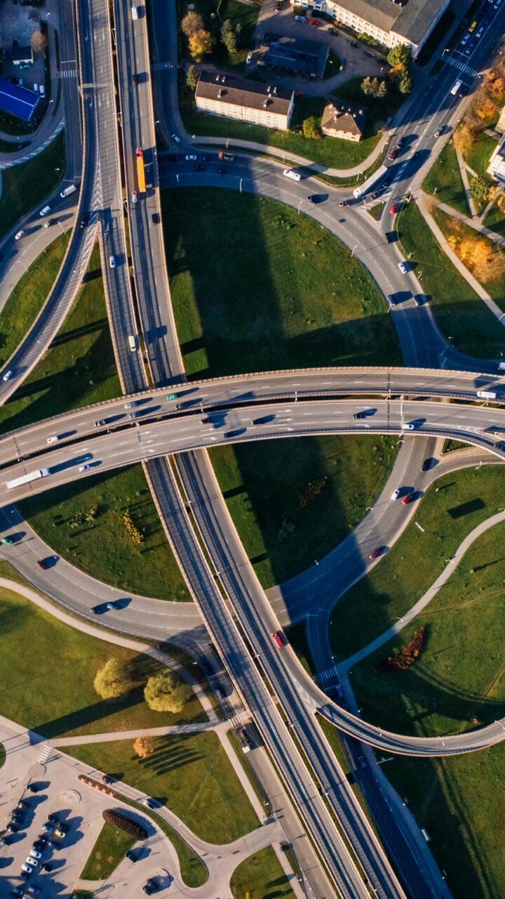Aerial shot of a complex highway intersection in a vibrant urban cityscape.